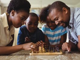 Família sorrindo enquanto jogam xadrez