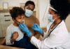 Médico faz nebulização em criança que está acompanhada pelo pai