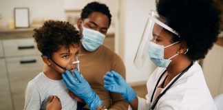 Médico faz nebulização em criança que está acompanhada pelo pai