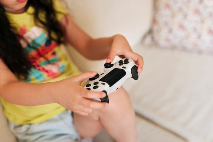 Menina no sofá joga videogame