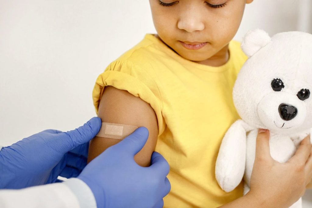 Criança recebe band-aid no braço após vacina