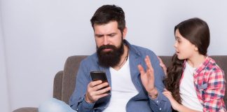 Pai olha para celular e ignora filha que tenta falar com ele