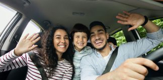 Pai, mãe e filho sorrindo e se divertindo dentro de um carro