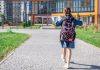 Menina de mochila caminha em direção à escola