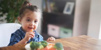 Criança em frente a um prato de vegetais