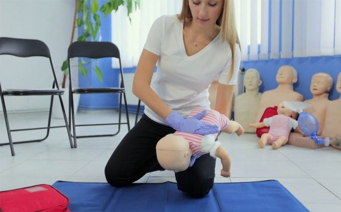 Mulher faz manobra para boneco bebê com engasgo