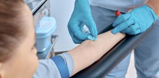 Menina com braço esticado faz exame de sangue