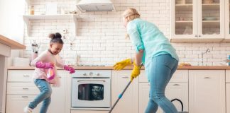 Mãe filha limpam piso da cozinha