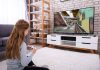 Menina joga videogame na tela da televisão