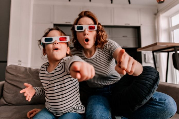 Mãe e filha assistem TV de óculos 3D