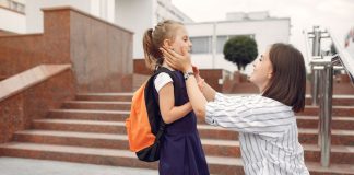 8 dicas para uma volta às aulas sem estresse para as crianças; Mãe se despede de filha na entrada da escola