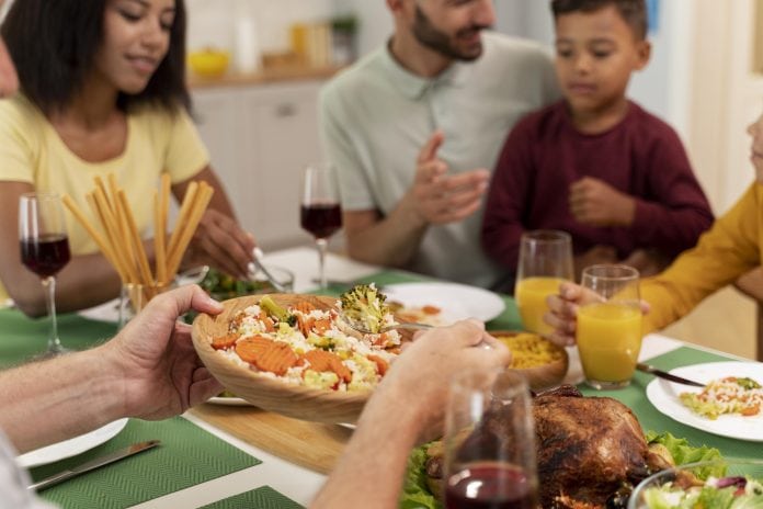 Crianças devem comer o que os pais oferecem ou só o que elas querem? Nem um nem outro; família jantando junta