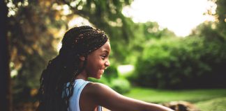 Menina de cabelos crespos tem penteado com tranças