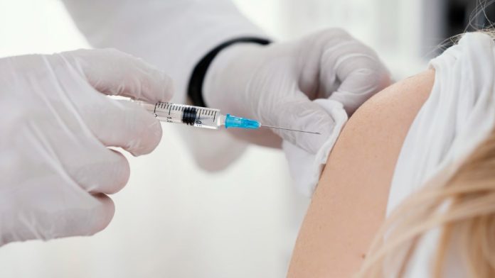 Aplicação de vacina no braço de paciente