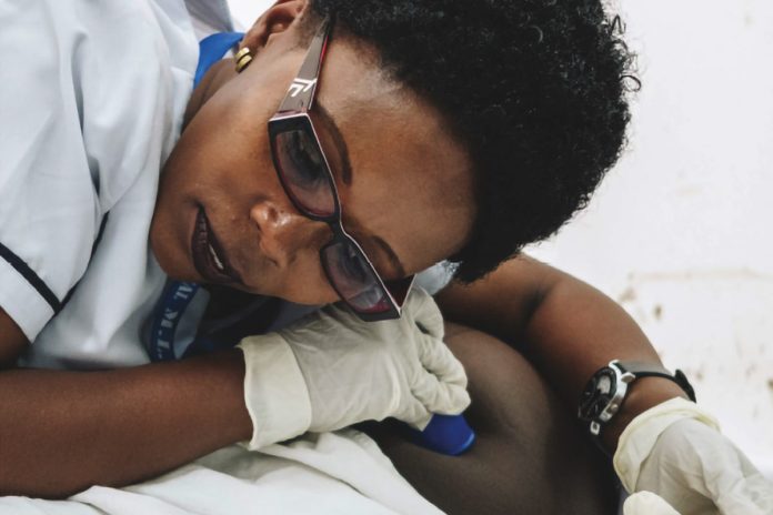 Médica ausculta coração de bebê na barriga de mulher grávida