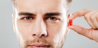 Homem segura pílula vermelha perto do ouvido