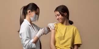 Médica aplica vacina HPV em garota adolescente