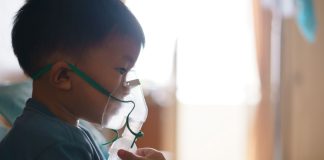 Menino asiático faz nebulização; crescem as internações de crianças por bronquiolite no outono