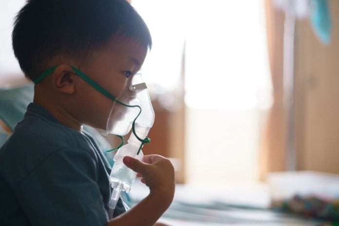 Menino asiático faz nebulização; crescem as internações de crianças por bronquiolite no outono