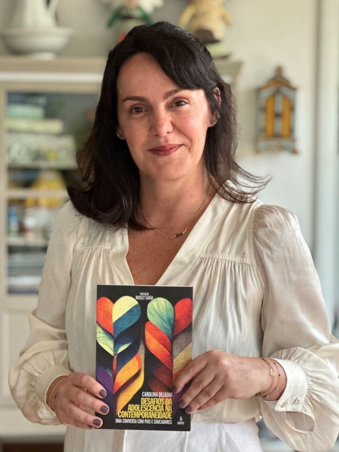 A educadora e jornalista Carolina Delboni mostra a capa de seu livro Desafios da adolescência na contemporaneidade