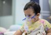 Criança pequena com Síndrome Respiratória Aguda Grave faz inalação em hospital
