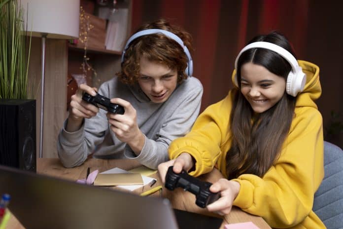 SBP alerta sobre impacto dos games na saúde dos adolescentes; dois adolescentes jogando videogame juntos em casa