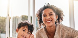 Mãe e filho fazem anotações sobre busca de escolas,