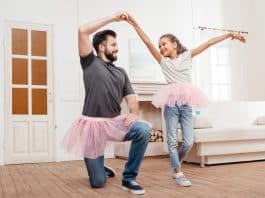 Pai praticando balé com sua filha na sala de casa