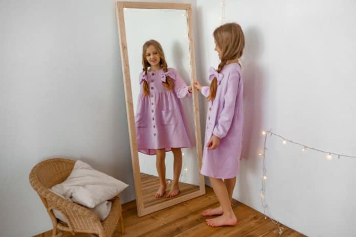 Menina se olha no espelho