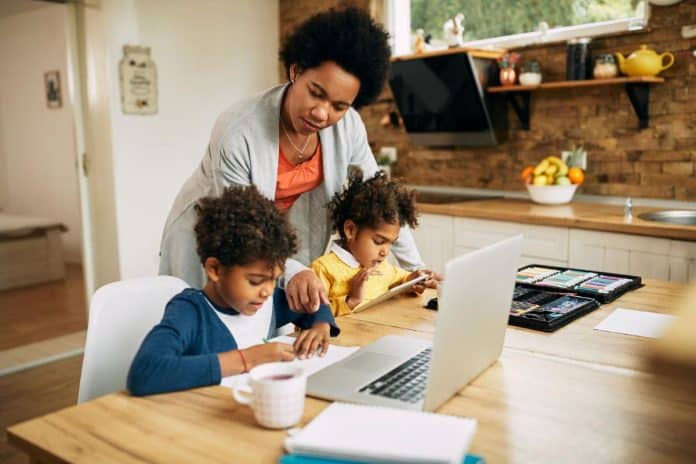 Mãe cuida dos filhos durante home office