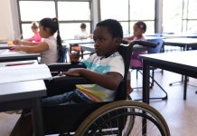 Menino com deficiência em cadeira de rodas na escola