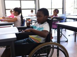 Menino com deficiência em cadeira de rodas na escola