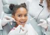 Dentista examina boca de menina negra