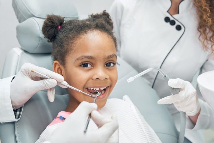 Dentista examina boca de menina negra