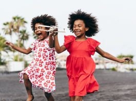 Crianças afro brincam com aviãozinho; brincadeiras da cultura africana estão presentes na infância brasileira