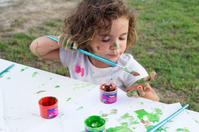 Criança faz pintura em papel