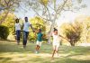 Família corre de mãos dadas em parque ao ar livre