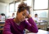 Menina olha triste para a mesa da escola; Repetência escolar: como buscar novos sentidos para o próximo ano letivo?