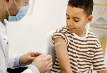 Menino recebe vacina no braço