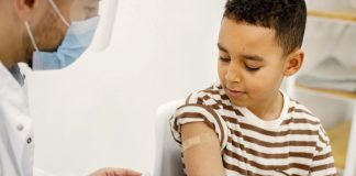 Menino recebe vacina no braço