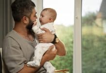 Pai segurando bebê; Quais são as mudanças na licença-paternidade no Brasil?