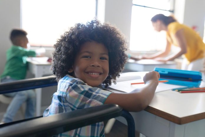Menino sorridente em sala de aula