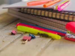 Cadernos e canetas de lista de material escolar usado
