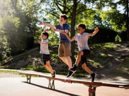 Meninos correm sob banco de madeira em parque