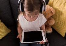 Criança olha para tela de tablet
