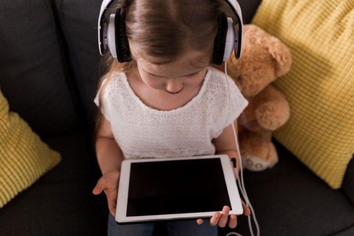Criança olha para tela de tablet