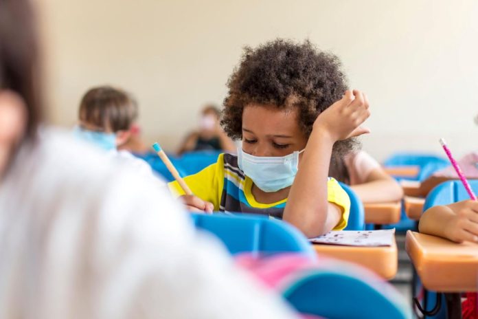 Aluno usa máscara em sala de aula