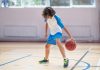 Menino joga basquete na quadra