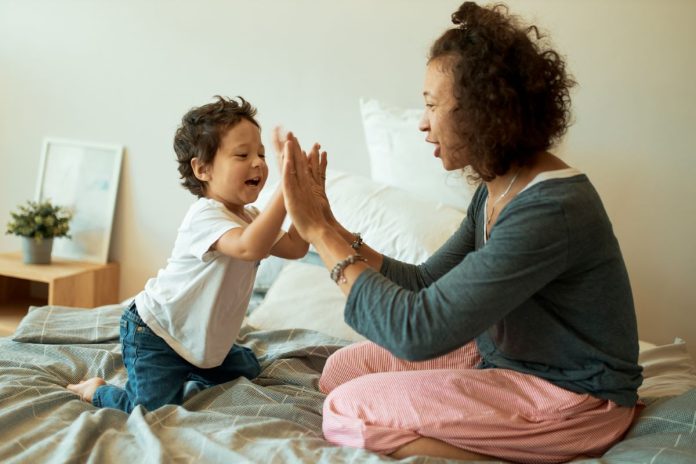 Mãe celebra com filho batendo palma da mão com palma da mão