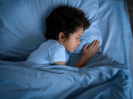 Menino dorme na cama
